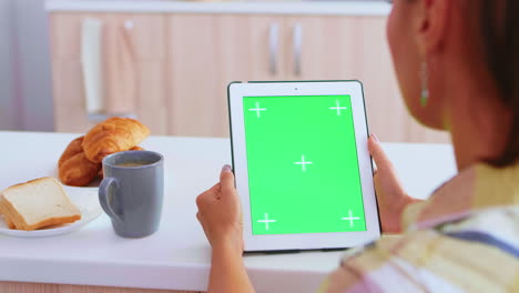 con un dispositivo de tableta con pantalla verde