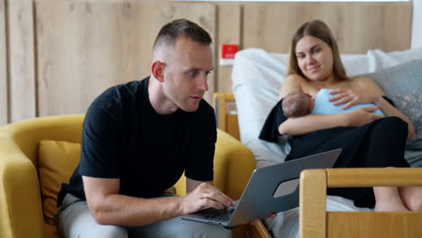 new parents with a newborn and a laptop