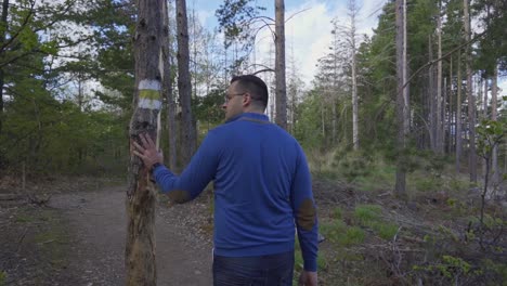 Man-walking-on-a-path-in-the-forest-in-the-Rhodope-mountain-region,-Bulgaria