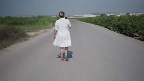 mujer caminando por un camino de campo
