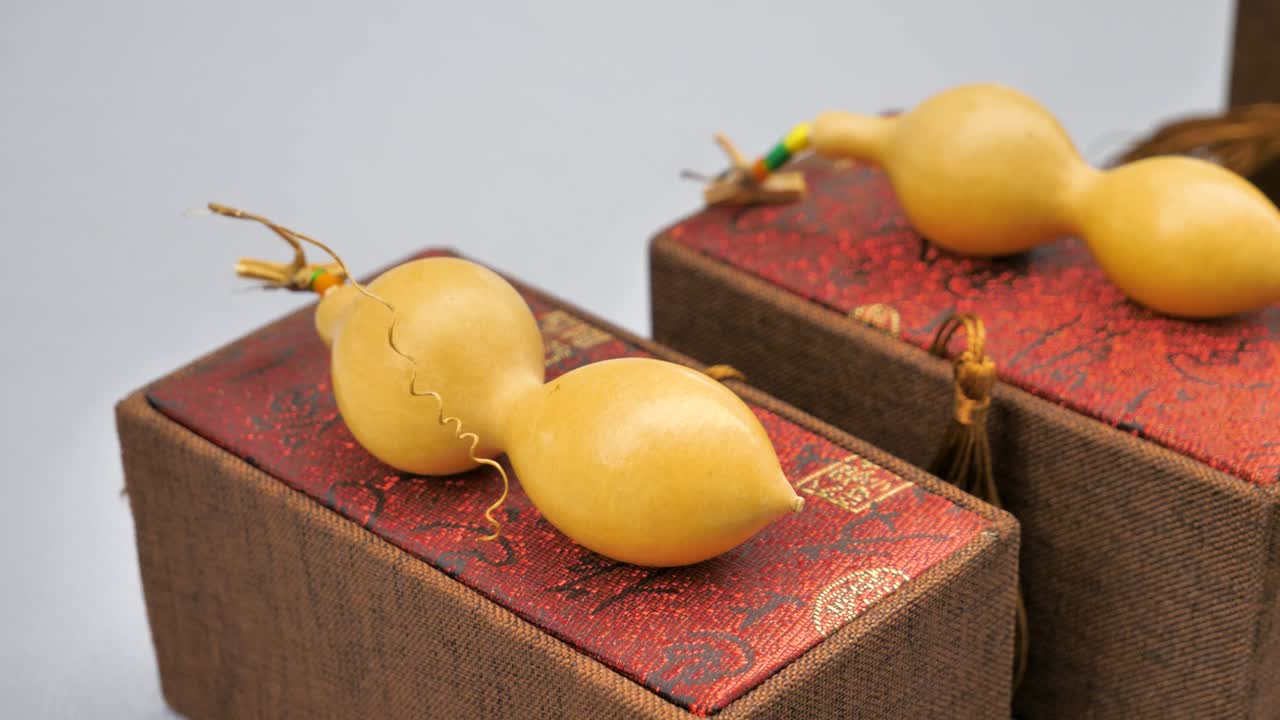 Close-up view of mini hulu pumpkin gourds displayed on decorative boxes in Liaocheng, China. Highlighting traditional artistry and elegant craftsmanship.