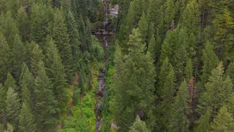 Aerial-landscape-view-of-a-small-waterfall-in-the-middle-of-the-forest