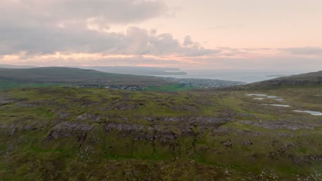 A green hilly landscape at sunset overlooking the Faroe Islands, a peaceful view