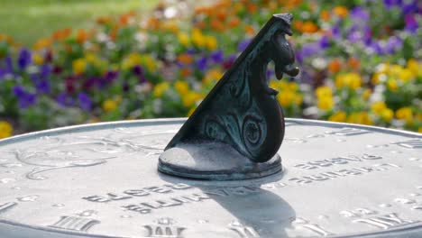 atenas, ga - 9 de octubre de 2018: panorámica lenta de un tiro apretado en un reloj de sol en un relajante jardín con flores en flor en una hermosa y soleada mañana de primavera