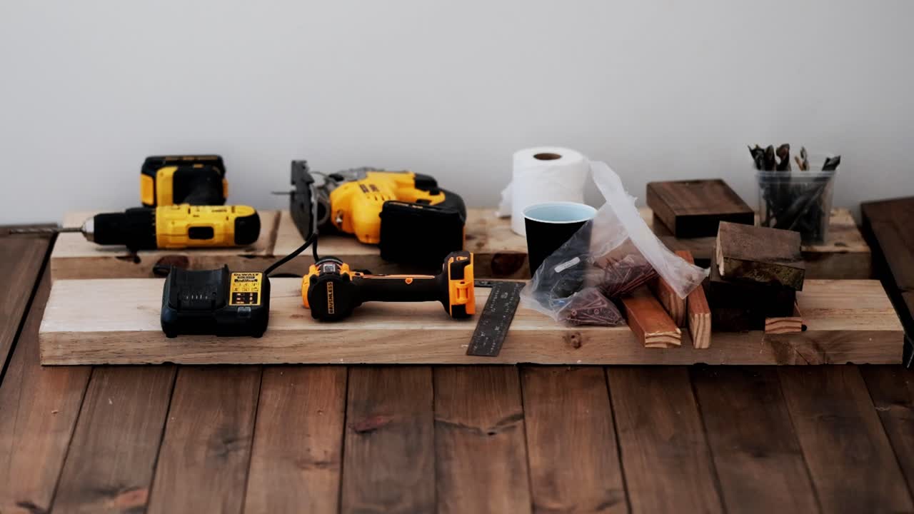 A selection of yellow power tools laid out for a DIY carpentry project