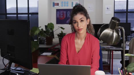 Happy-biracial-female-creative-using-computer-at-casual-office,-in-slow-motion