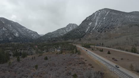 aerial dolly shot following along interstate 70 with fresh snow on distant mountains