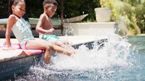 happy african american siblings playing at pool, in slow motion