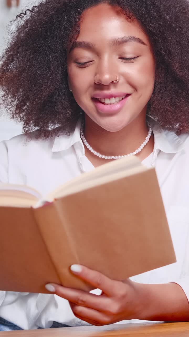 Young smiling ethnic african american woman leafing through pages of textbook
