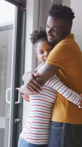 video de una feliz pareja afroamericana abrazándose en casa