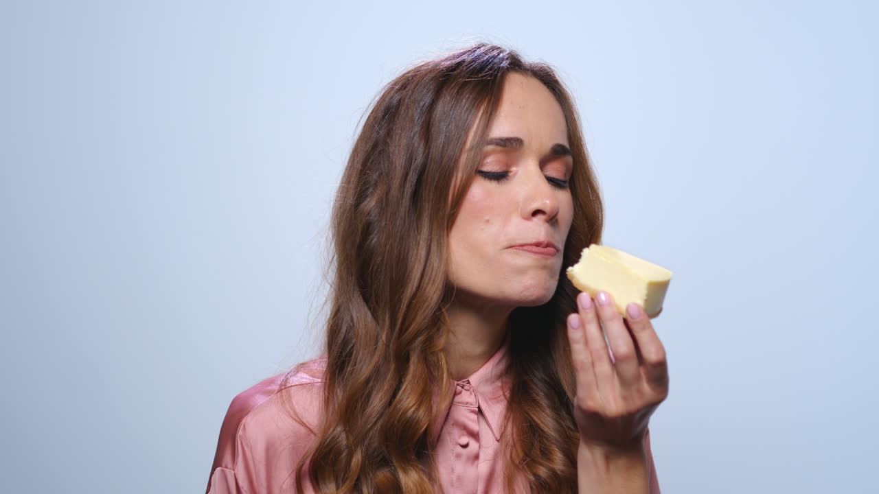 mujer de negocios sonriente comiendo pastel. mujer hambrienta probando pastel de queso en el estudio