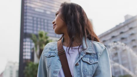 Asian-woman-walking-wearing-earphones-and-using-smartwatch