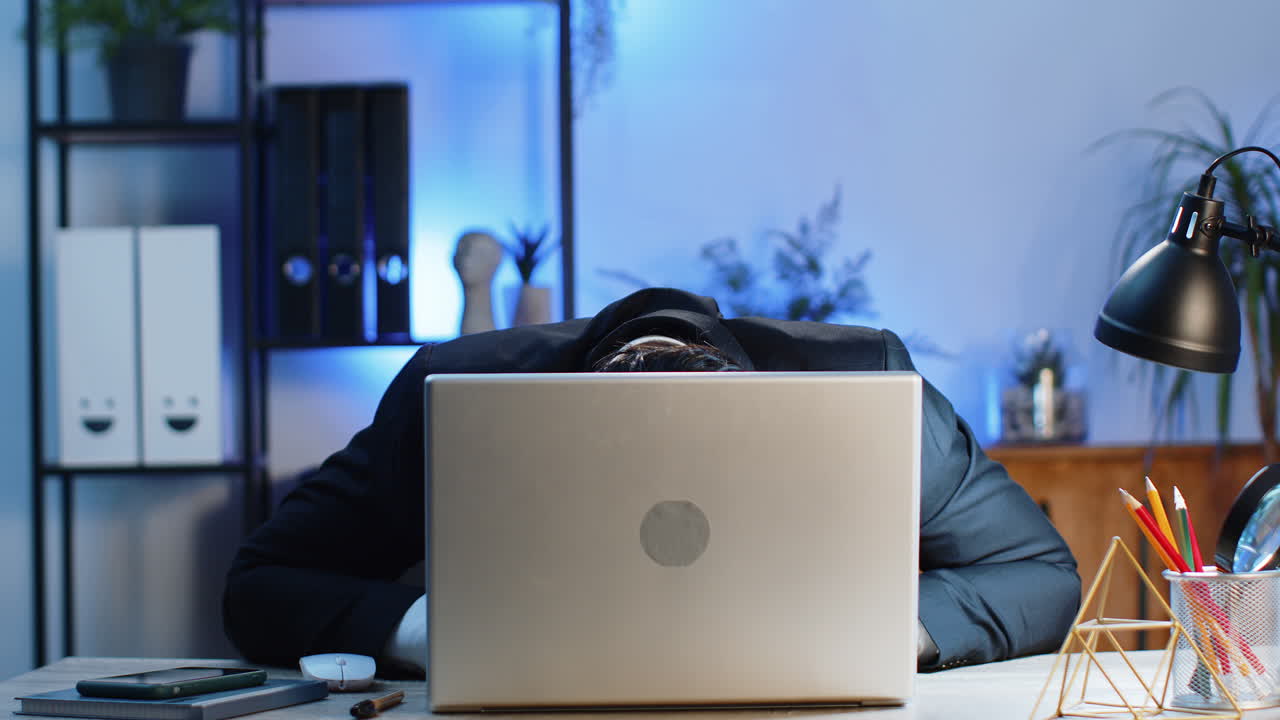 Office businessman hiding behind laptop computer making funny silly face fooling around disrespect