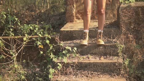 long shot of a beautiful women's legs standing on the stairs, and wearing boots