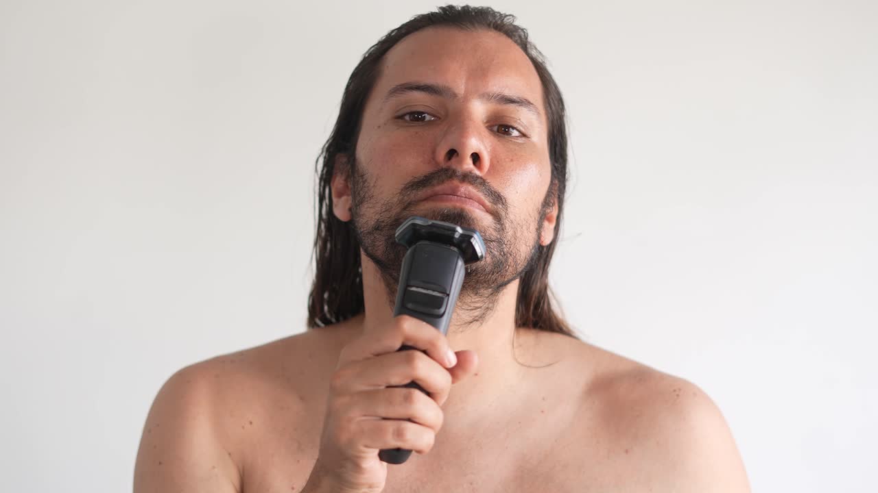 un hombre frente a un espejo se afeita la cara