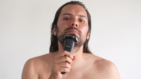 a man in front of a mirror shaves his face