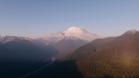 aerial footage of mount rainier and the valley before it in the golden light of sunrise