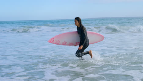 female surfer with surfboard running towards the coast 4k