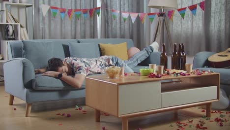 drunk man sleeping on sofa after party