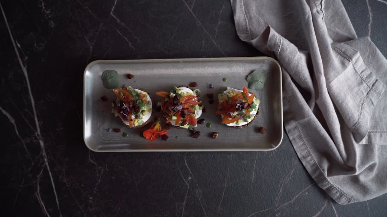 a menudo se acompaña de productos locales como aceite de oliva, queso feta, tomates y hierbas