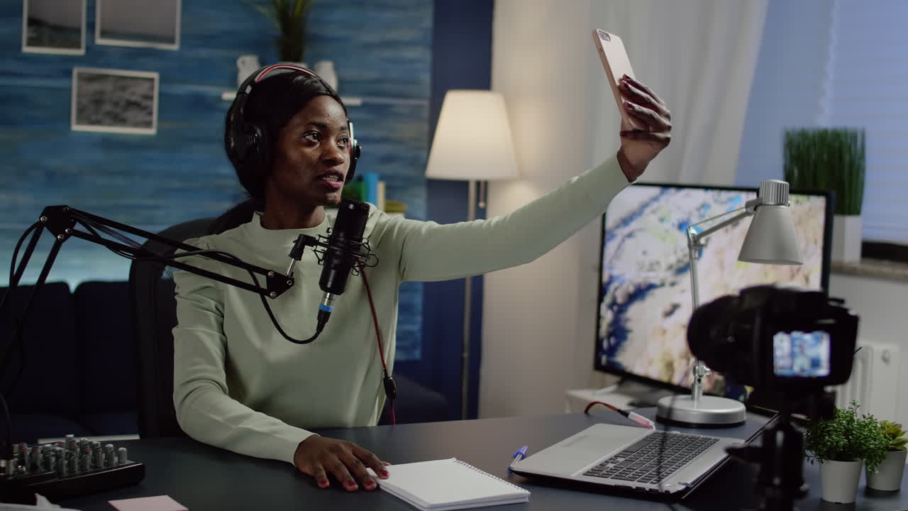 Black woman vlogger taking selfie using smartphone during streaming