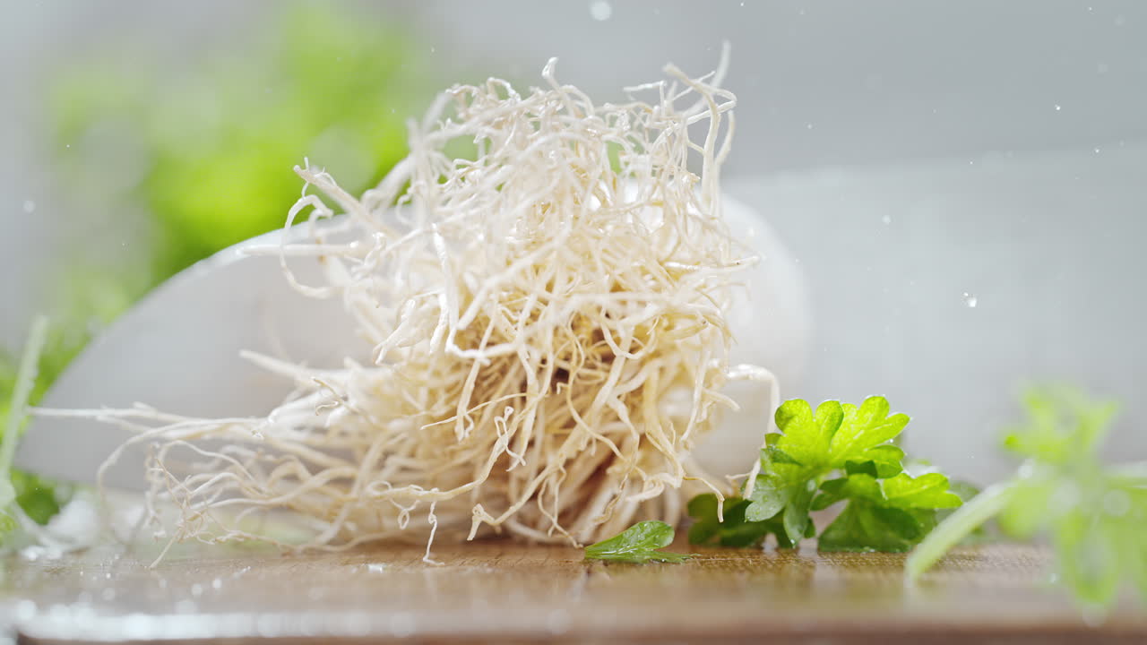 매크로와 느린 동작으로 나무 절단판에 날카로운 주방 칼로 털이 많은 뿌리를 잘라내는 것