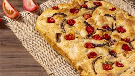 traditional italian focaccia with pepperoni, cherry tomatoes, black olives, rosemary ando onion - homemade flat bread focaccia