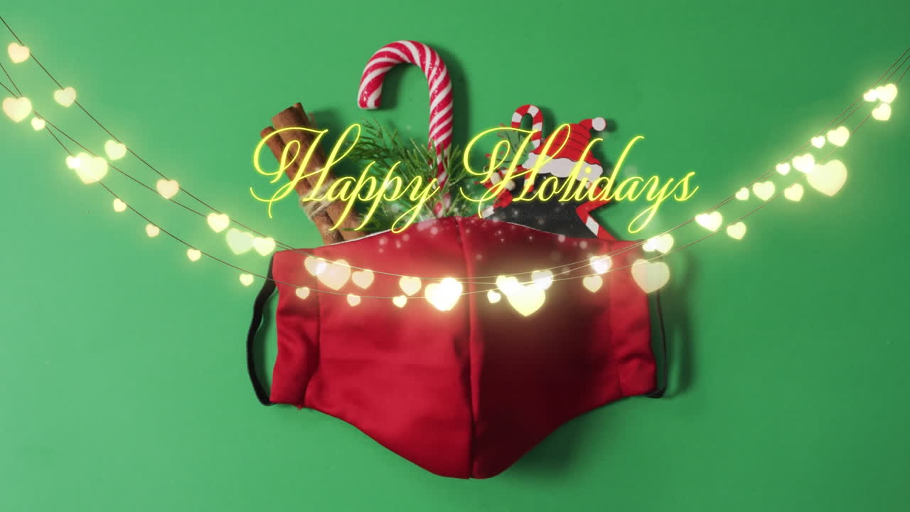 녹색 배경에 빛과 얼굴 마스크 위에 행복한 휴일 크리스마스 텍스트의 애니메이션