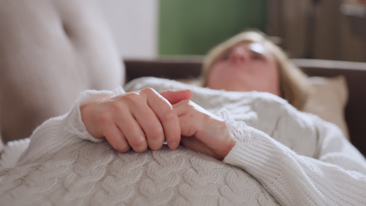 Reflective soul lying on comfortable sofa touching fingertips over knit blanket wearing cozy sweater breathing steadily in calm therapeutic session with soft natural light surroundings