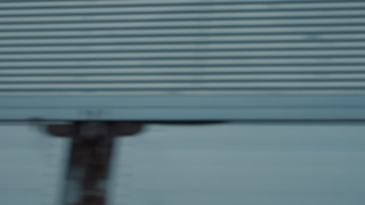 distant view of paraglider and hot air balloon gliding near power lines above tree silhouette while truck passes on road under pastel dusk sky