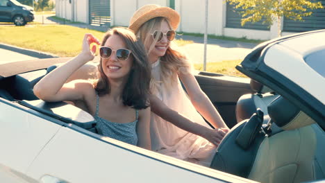 two women enjoying a summer road trip in a convertible