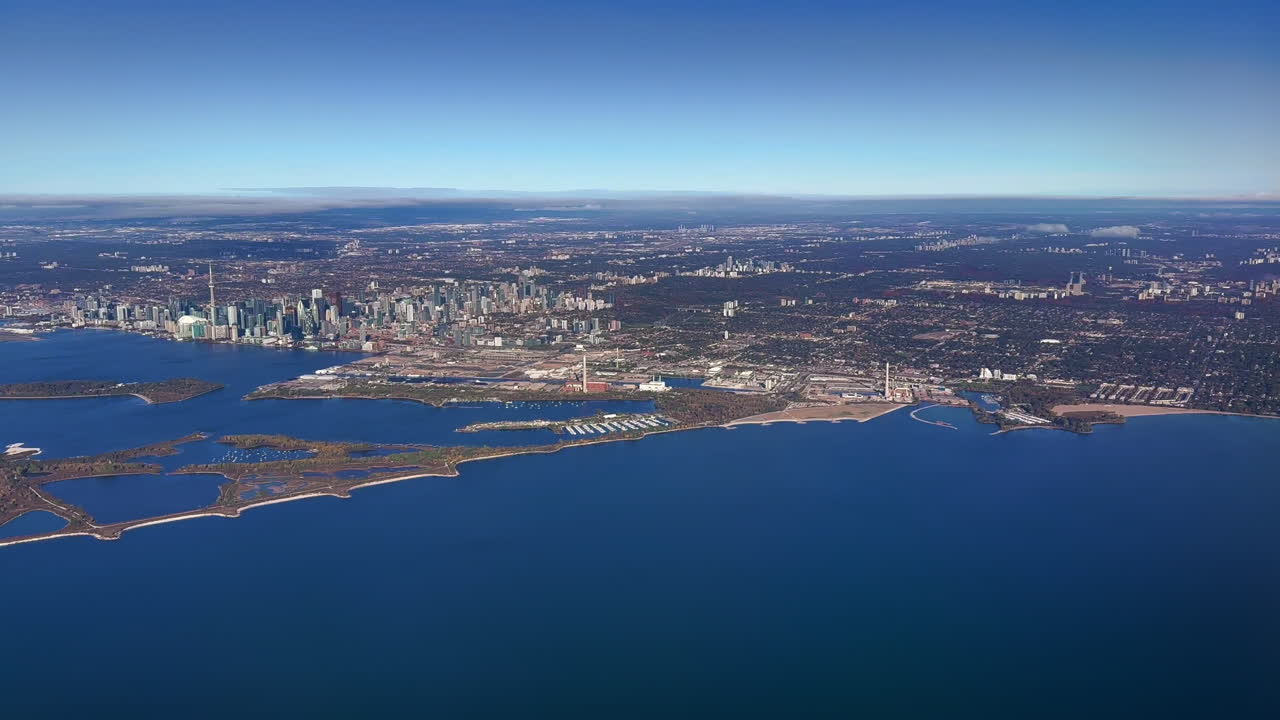 Aerial view of Toronto and surrounding environs from an airplane flying south of the city, wide shot