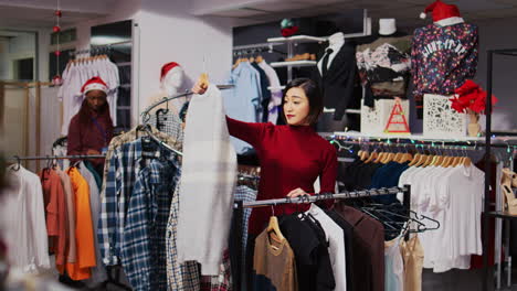 smiling client in christmas ornate fashion shop looking to purchase comfortable clothes on clearance, taking advantage of reduced prices during holiday season promotional sales