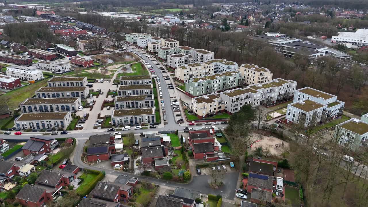 Res brick single family houses and new devleoped apartment buildings with green rooftop garden. German architecture in american town in winter season. Drone forward wide shot.