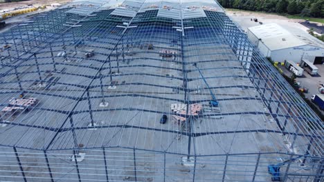 la industria de la construcción de vigas de hierro metálico marco de almacén sitio de construcción vista aérea inclinación hacia abajo deriva