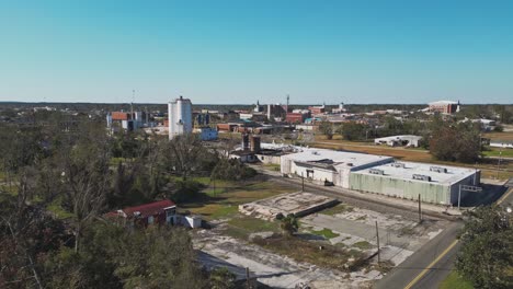 industrial buildings with silos on sunny day in valdosta city, lowndes county, georgia. wide aerial shot