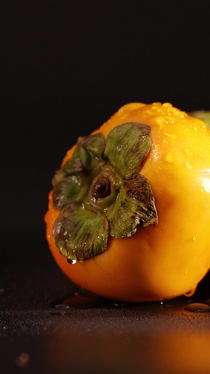primer plano de persimiones en una superficie oscura