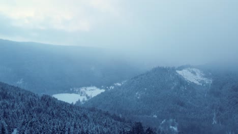 winter mountain aerial view of cloudy forest covered snow in vosges france 4k