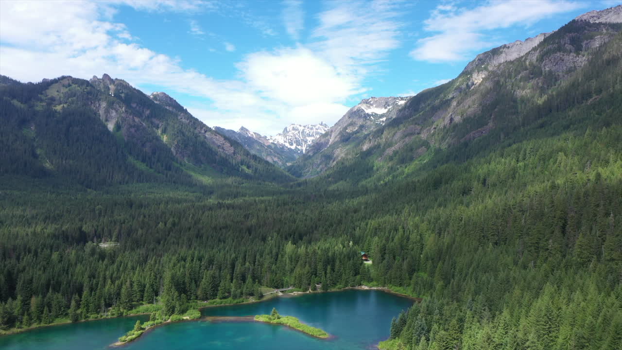 descenso aéreo sobre el lago turquesa ubicado en un valle de montaña