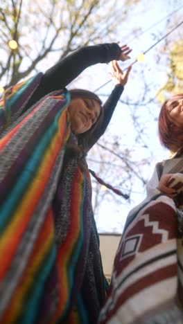 two women dancing outdoors in colorful ponchos