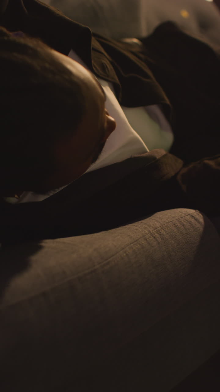 video vertical de un hombre confundido despertando sentado en el sofá después de beber alcohol en una fiesta de casa sufriendo de resaca 1