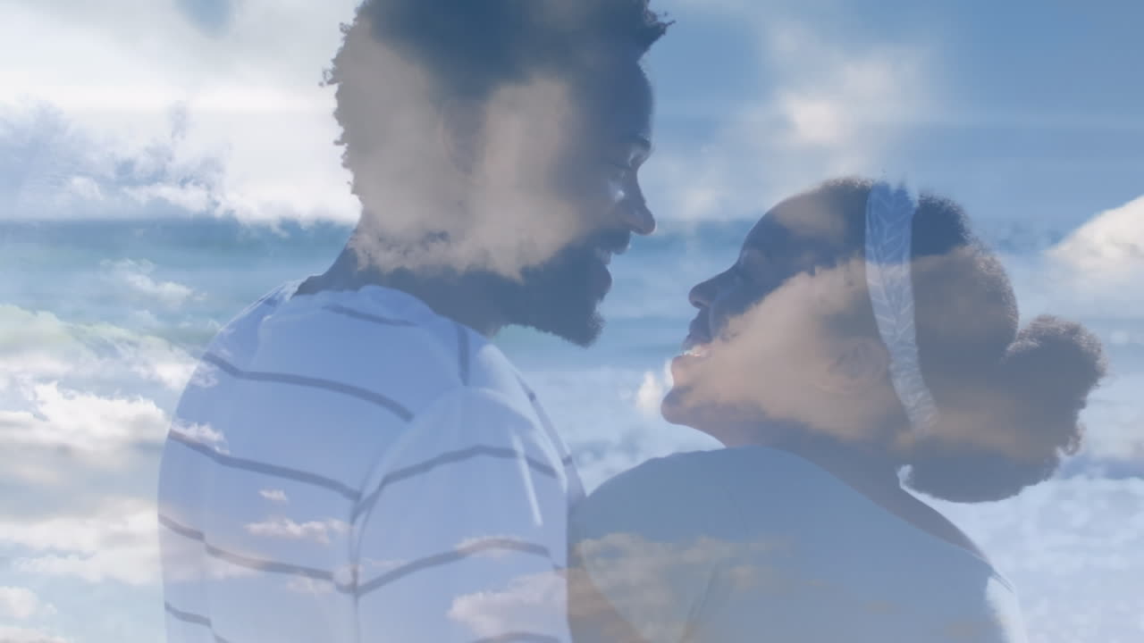 Animation of clouds over african american couple at beach