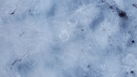 Man-walking-on-a-frozen-lake-wearing-a-white-bag-pack,-mask-and-jacket