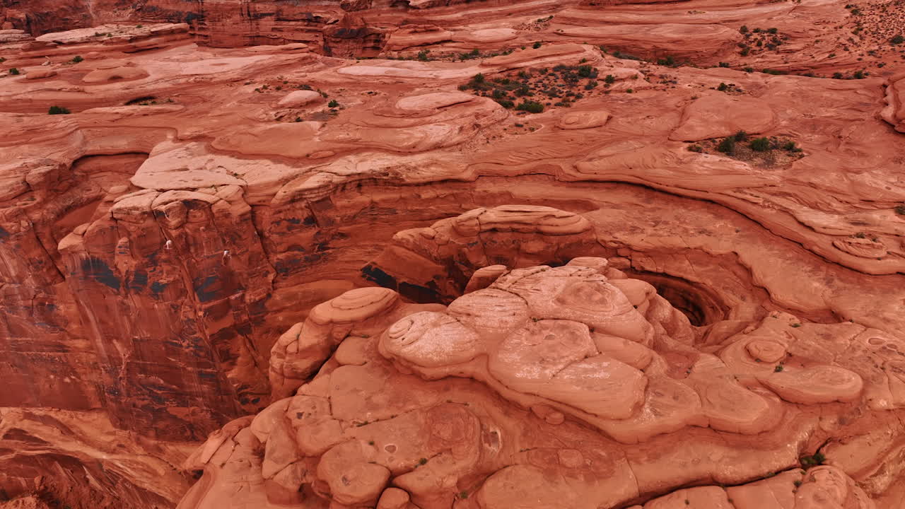 Volo di drone sopra le cime piatte dei canyon rossi. Rocce dalle forme bizzarre con pendii scoscesi all'Arches National Park, Utah, USA