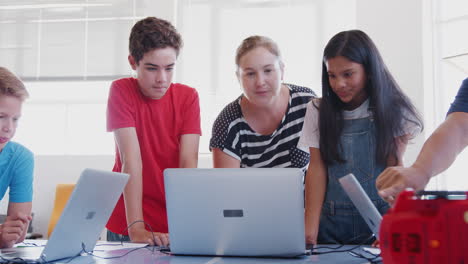 Schüler-Mit-Einer-Lehrerin-Im-Computer-Codierungskurs-Nach-Der-Schule-Lernen,-Roboterfahrzeuge-Zu-Programmieren