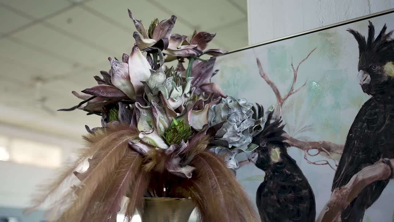 A stunning floral display blends with wildlife art in a bright room, highlighting nature's beauty and creativity in a captivating atmosphere