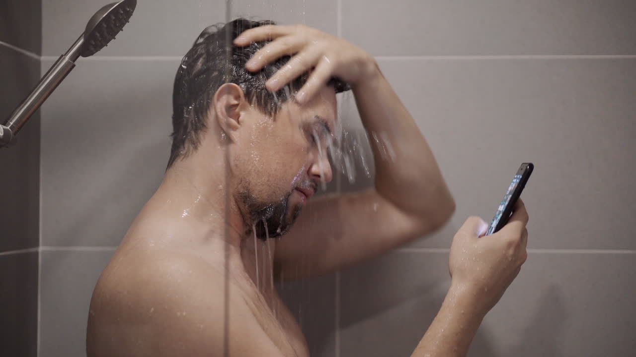 hombre usando el teléfono en la ducha