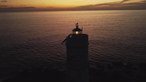 impresionante vista aérea de drones de destellos de faro con seagul en la parte superior de la cabeza, puesta de sol