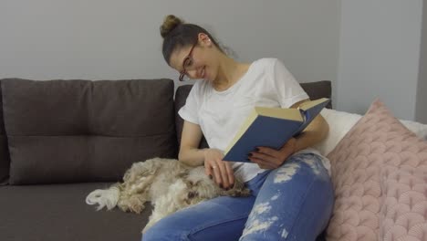 una mujer joven con un lindo perro en casa.