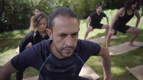personas enfocadas practicando yoga en el parque